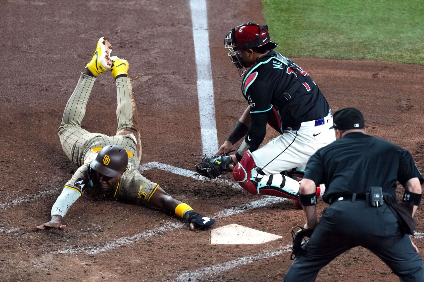 San Diego Padres left fielder Jurickson Profar slides safely past the tag of Arizona Diamondbacks catcher Gabriel Moreno.