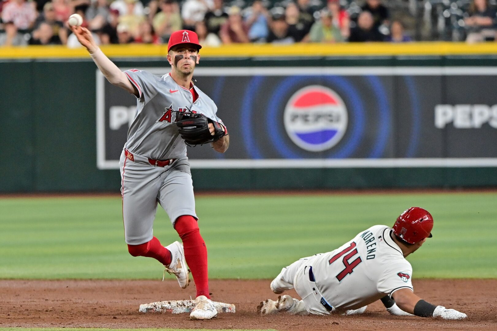 Diamondbacks catcher Gabriel Moreno slides into second as Angels shortstop Zach Neto attempts to turn a double play.