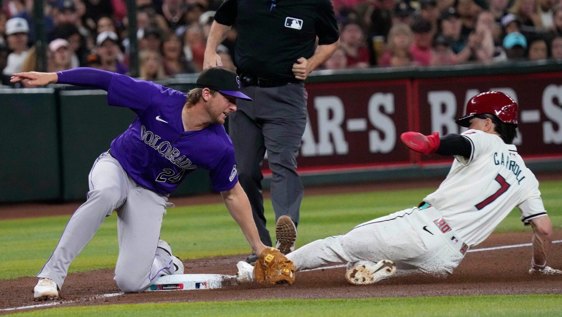 Diamondbacks outfielder Corbin Carroll slides into third base on a stolen base attempt.