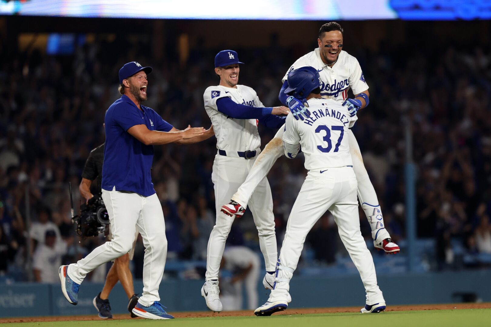 Dodgers celebrate after Teoscar Hernandez hits a walk-off single against Diamondbacks closer Paul Sewald.