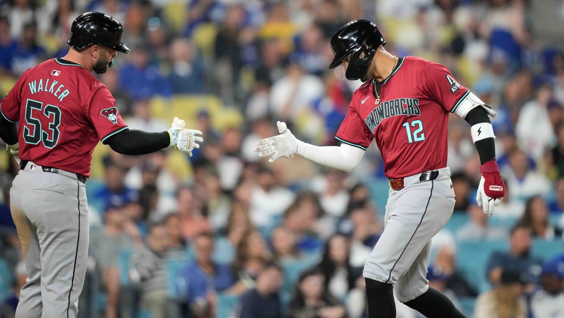 Diamondbacks outfielder Lourdes Gurriel Jr. and first baseman Christian Walker celebrate at home plate after Gurriel's two-run home run against the Dodgers.