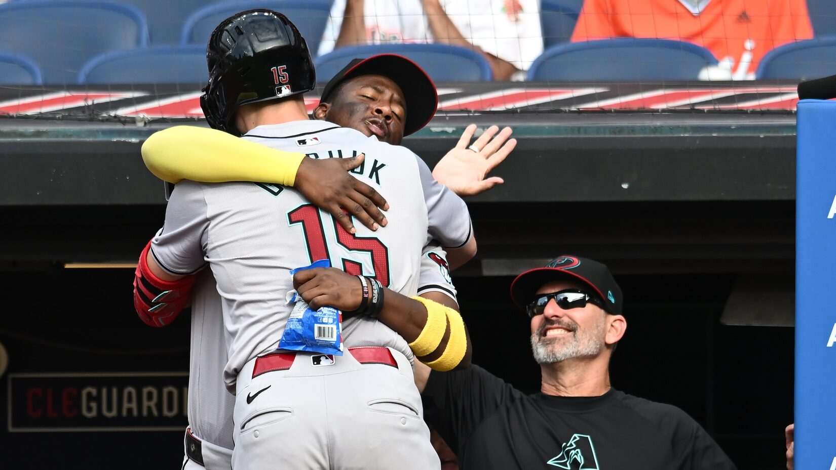 Arizona Diamondbacks shortstop Geraldo Perdomo hugs outfielder Randal Grichuk in front of manager Torey Lovullo after Grichuk hit a home run at Progressive Field.