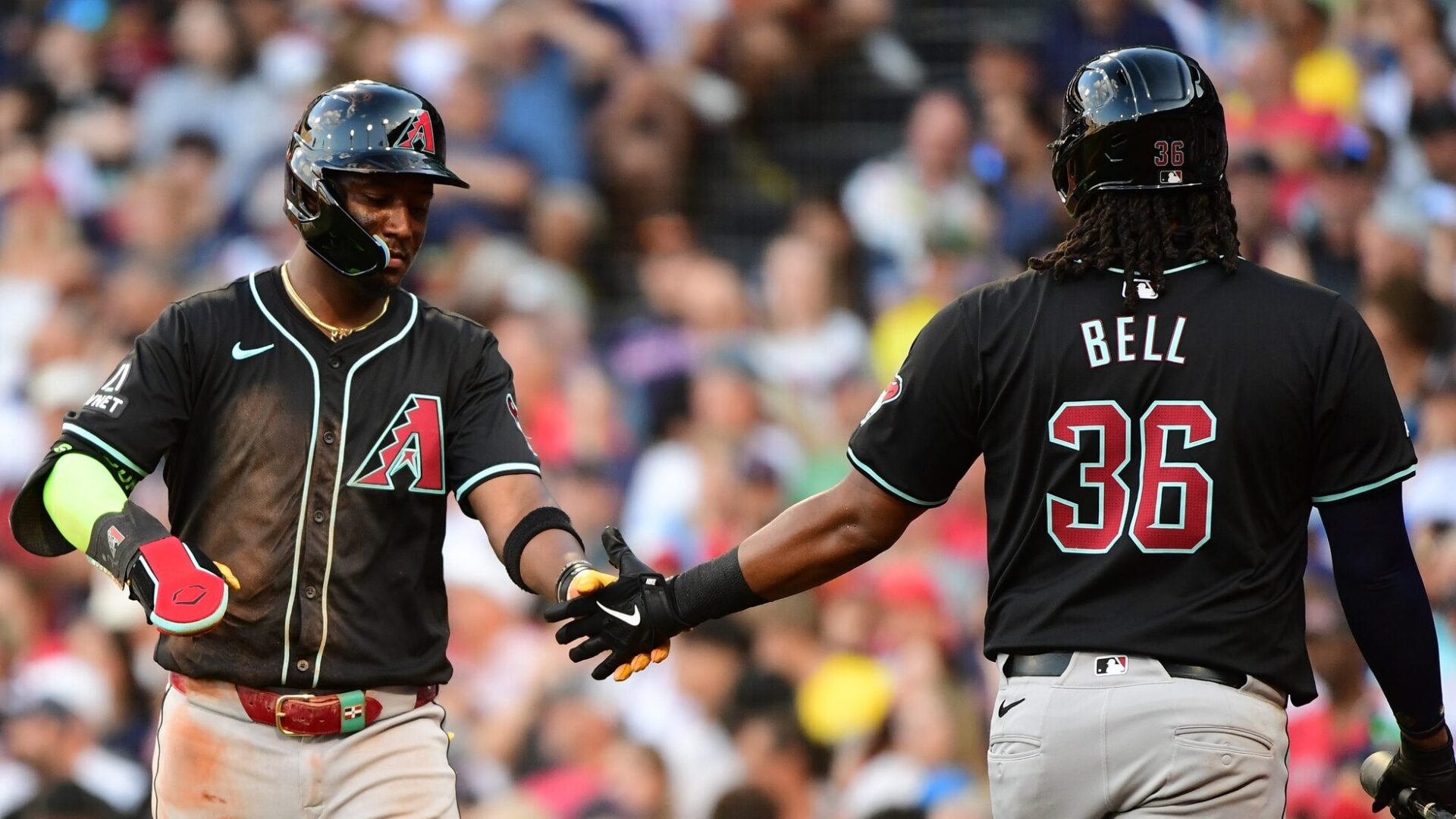 Diamondbacks shortstop Geraldo Perdomo high fives Josh Bell after scoring a run against the Boston Red Sox.