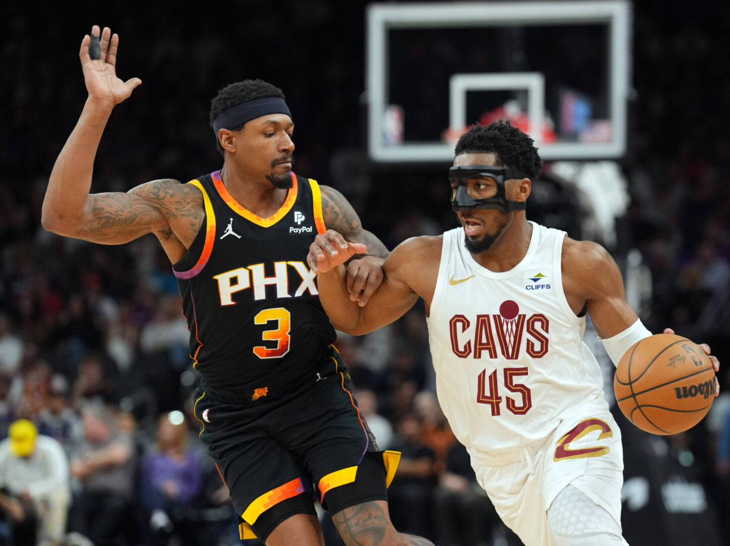 Apr 3, 2024; Phoenix, Arizona, USA; Cleveland Cavaliers guard Donovan Mitchell (45) dribbles against Phoenix Suns guard Bradley Beal (3) during the second half at Footprint Center. Mandatory Credit: Joe Camporeale-Imagn Images