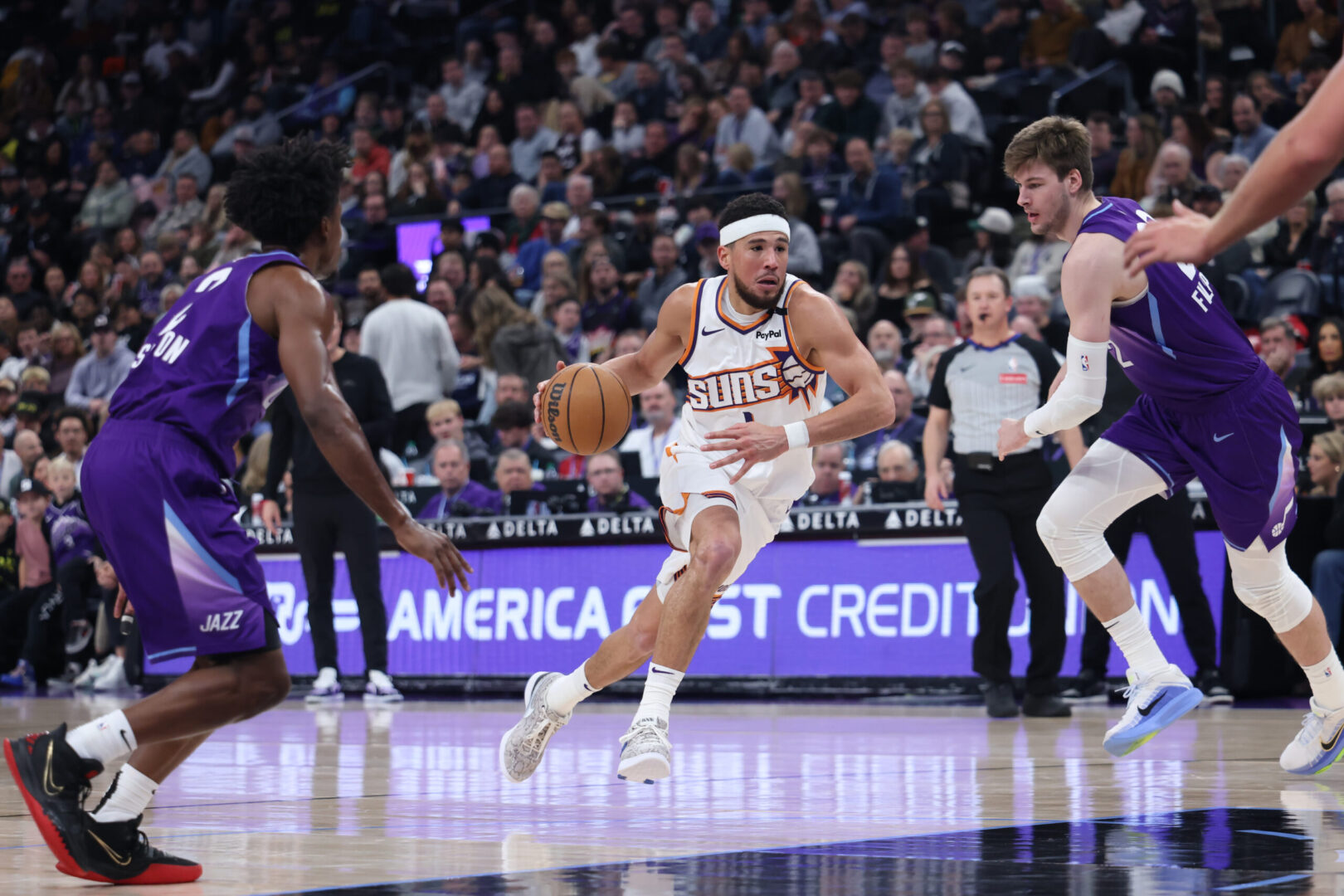 Dec 13, 2024; Salt Lake City, Utah, USA; Phoenix Suns guard Devin Booker (1) goes to the basket between Utah Jazz guard Collin Sexton (2) and forward Kyle Filipowski (22) during the third quarter at Delta Center. Mandatory Credit: Rob Gray-Imagn Images
