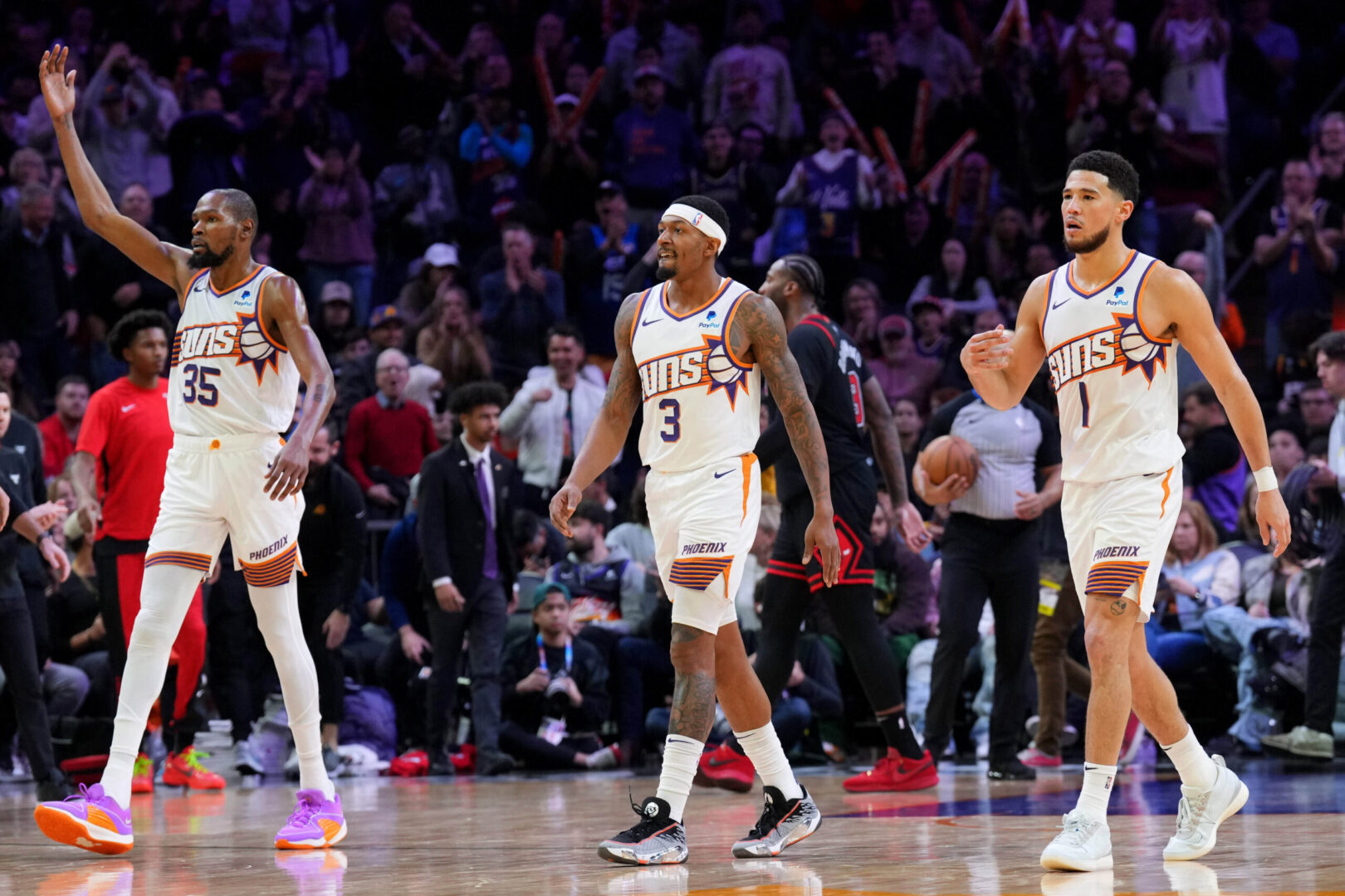 Jan 22, 2024; Phoenix, Arizona, USA; Phoenix Suns forward Kevin Durant (35) and Phoenix Suns guard Bradley Beal (3) and Phoenix Suns guard Devin Booker (1) reacts during the second half of the game against the Chicago Bulls at Footprint Center. Mandatory Credit: Joe Camporeale-Imagn Images