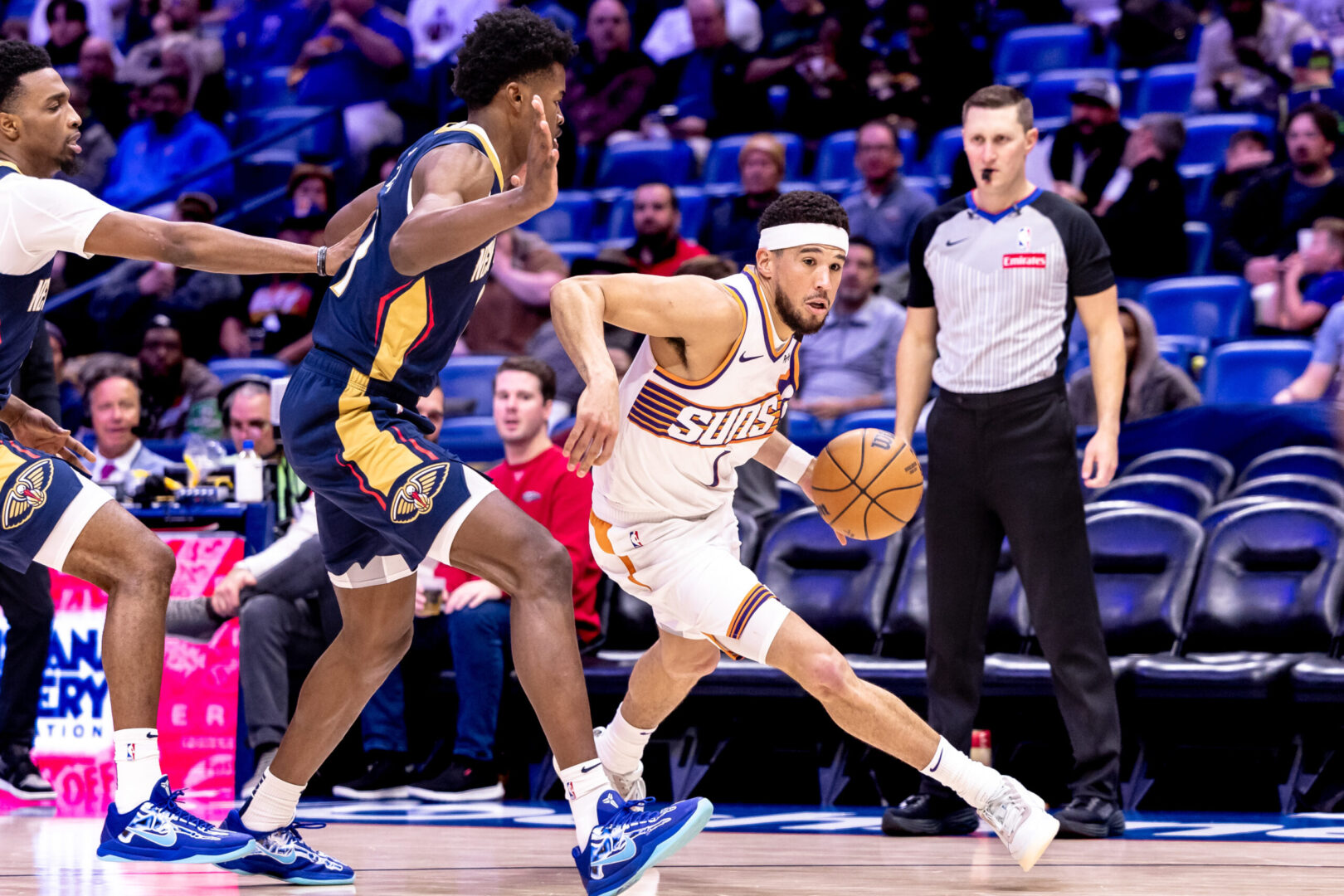 Dec 5, 2024; New Orleans, Louisiana, USA; Phoenix Suns guard Devin Booker (1) dribbles against New Orleans Pelicans center Yves Missi (21) during the second half at Smoothie King Center. Mandatory Credit: Stephen Lew-Imagn Images