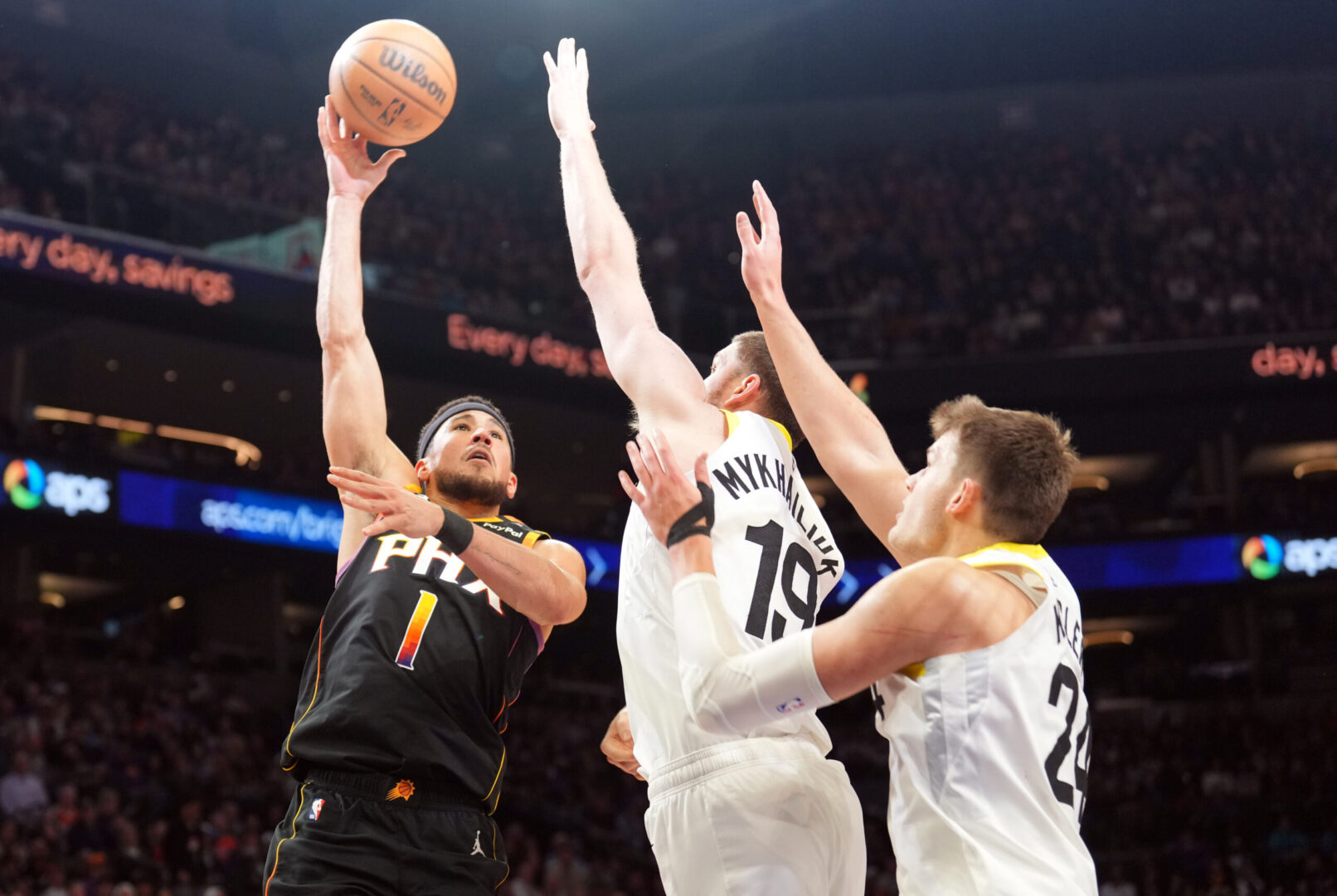 Feb 7, 2025; Phoenix, Arizona, USA; Phoenix Suns guard Devin Booker (1) shoots over Utah Jazz guard Svi Mykhailiuk (19) and Utah Jazz center Walker Kessler (24) during the second half at Footprint Center. Mandatory Credit: Joe Camporeale-Imagn Images