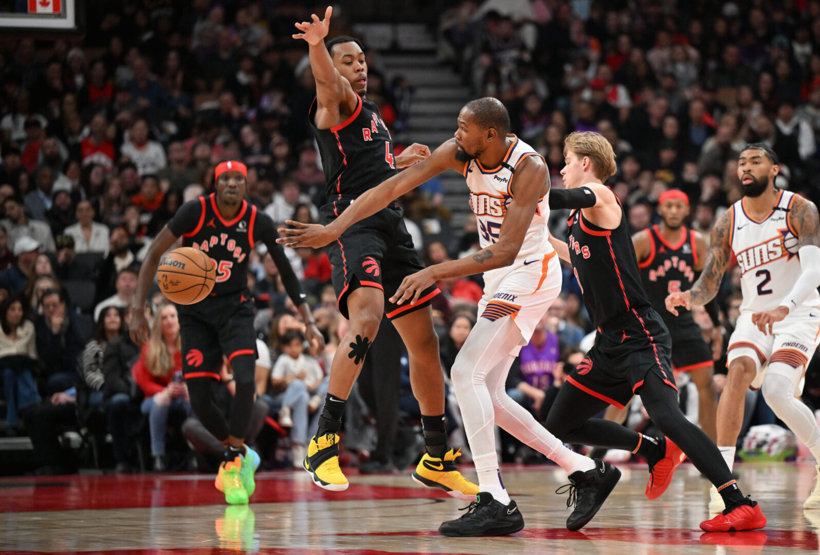 Feb 23, 2025; Toronto, Ontario, CAN; Phoenix Suns forward Kevin Durant (35) passes the ball past Toronto Raptors forward Scottie Barnes (4) in the first half at Scotiabank Arena. Mandatory Credit: Dan Hamilton-Imagn Images