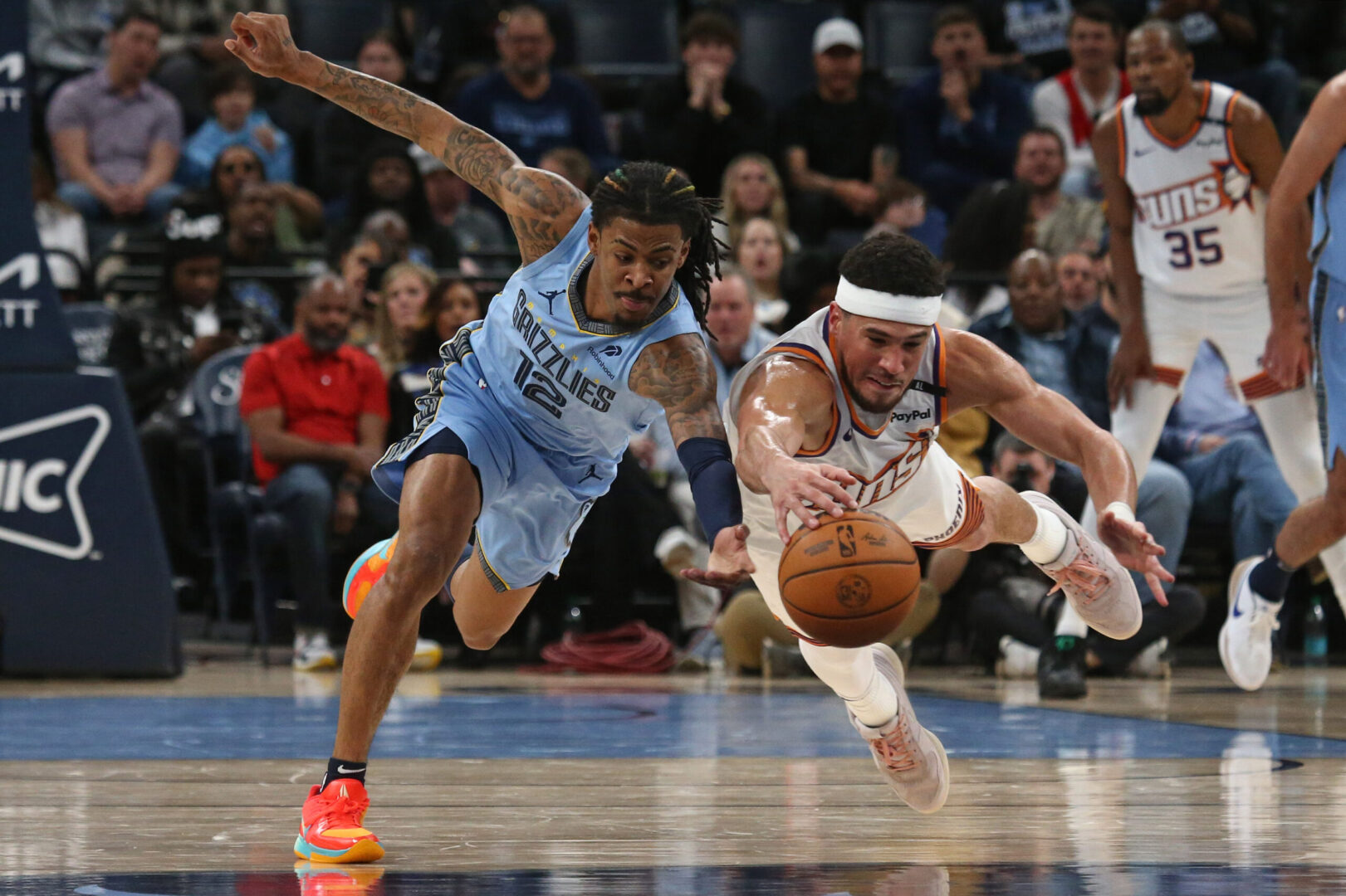 Feb 25, 2025; Memphis, Tennessee, USA; Memphis Grizzlies guard Ja Morant (12) and Phoenix Suns guard Devin Booker (1) dive for a loose ball during the second quarter at FedExForum. Mandatory Credit: Petre Thomas-Imagn Images