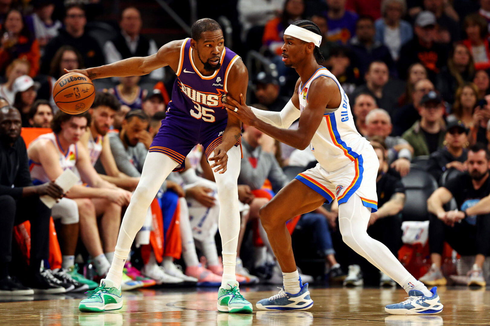 Mar 3, 2024; Phoenix, Arizona, USA; Phoenix Suns forward Kevin Durant (35) handles the ball against Oklahoma City Thunder guard Shai Gilgeous-Alexander (2) during the second quarter at Footprint Center. Mandatory Credit: Mark J. Rebilas-Imagn Images