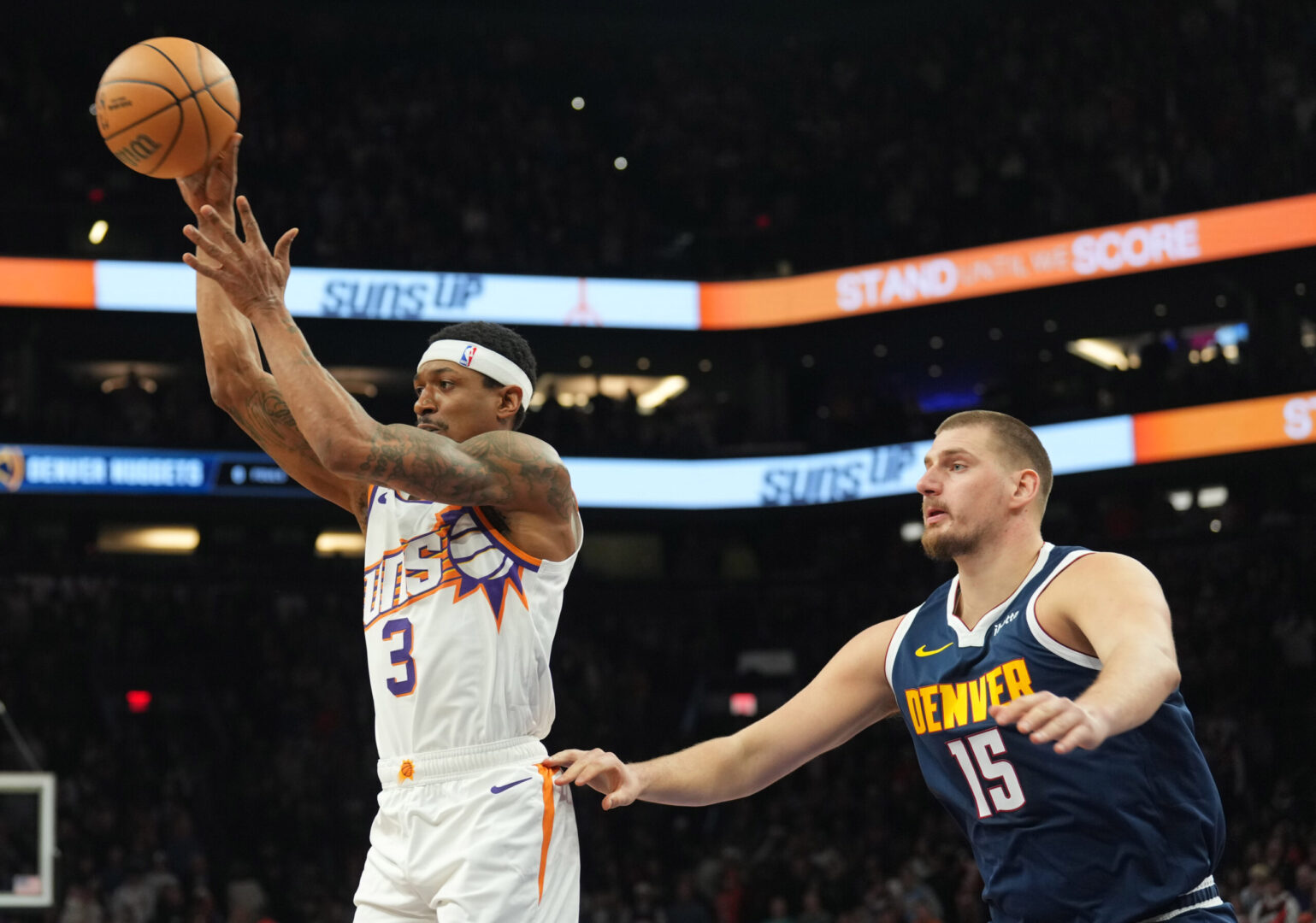 Dec 25, 2024; Phoenix, Arizona, USA; Phoenix Suns guard Bradley Beal (3) passes the ball by Denver Nuggets center Nikola Jokic (15) during the first half at Footprint Center. Mandatory Credit: Joe Camporeale-Imagn Images