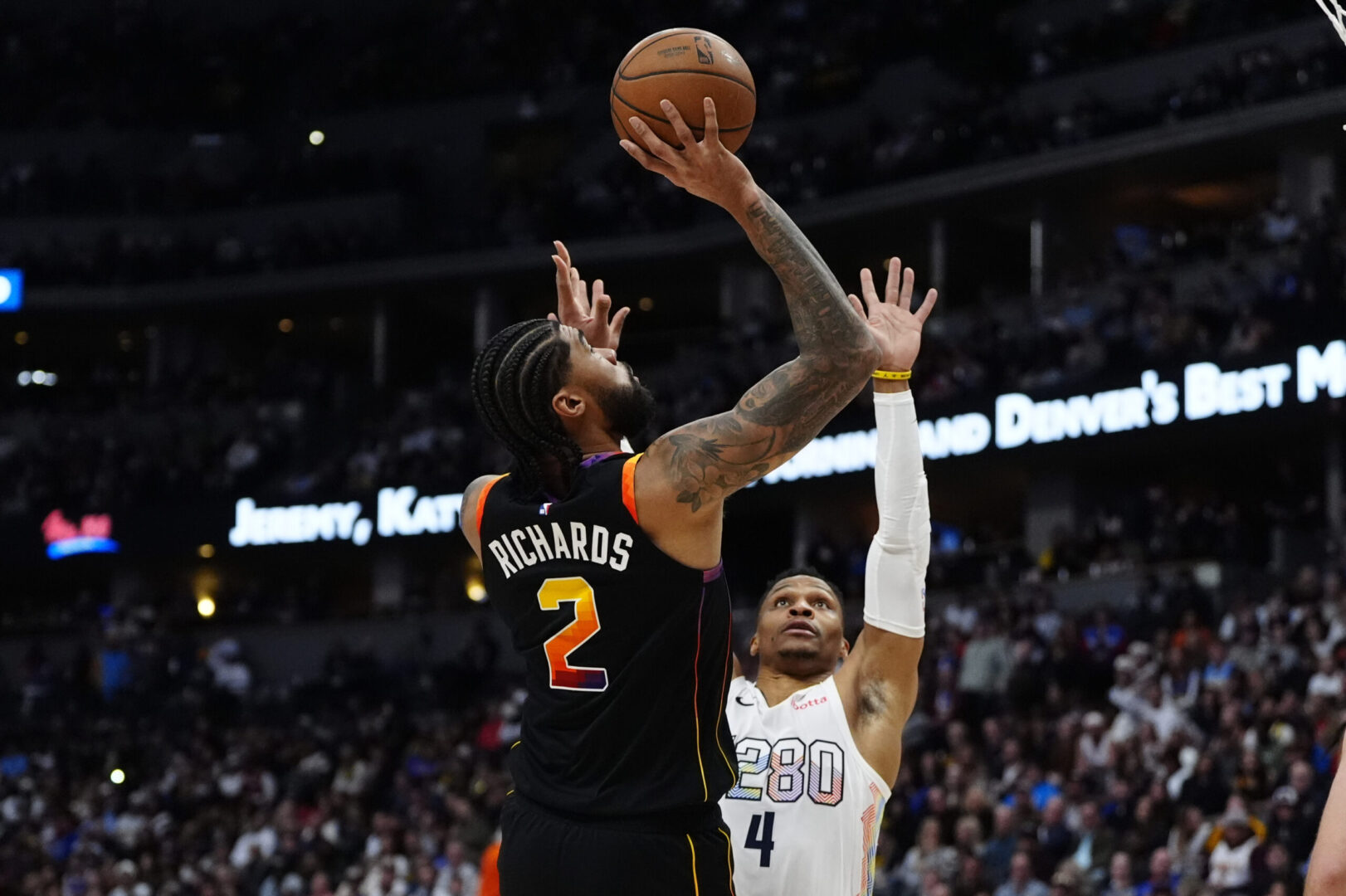 Mar 7, 2025; Denver, Colorado, USA; Phoenix Suns center Nick Richards (2) shoots the ball over Denver Nuggets guard Russell Westbrook (4) in the second quarter at Ball Arena. Mandatory Credit: Ron Chenoy-Imagn Images