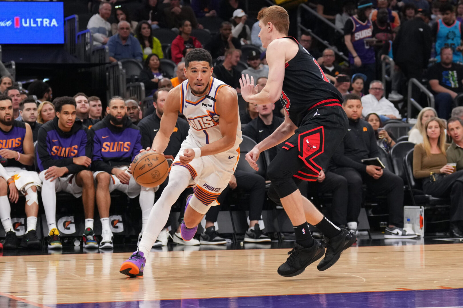 Mar 19, 2025; Phoenix, Arizona, USA; Phoenix Suns guard Devin Booker (1) dribbles against Chicago Bulls guard Kevin Huerter (13) during the second half at PHX Aena. Mandatory Credit: Joe Camporeale-Imagn Images