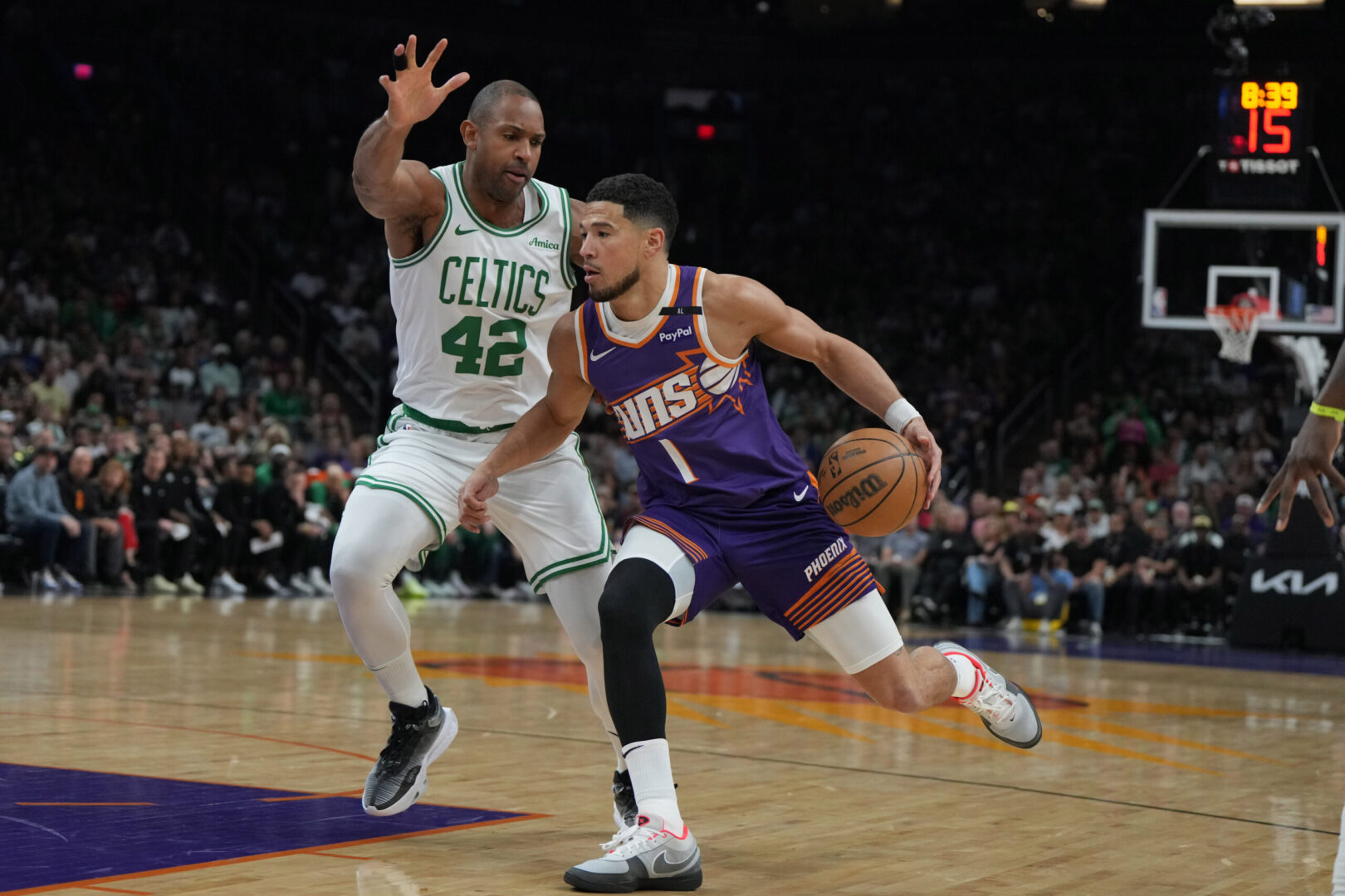 Mar 26, 2025; Phoenix, Arizona, USA; Phoenix Suns guard Devin Booker (1) drives on Boston Celtics center Al Horford (42) during the first half at Footprint Center. Mandatory Credit: Rick Scuteri-Imagn Images