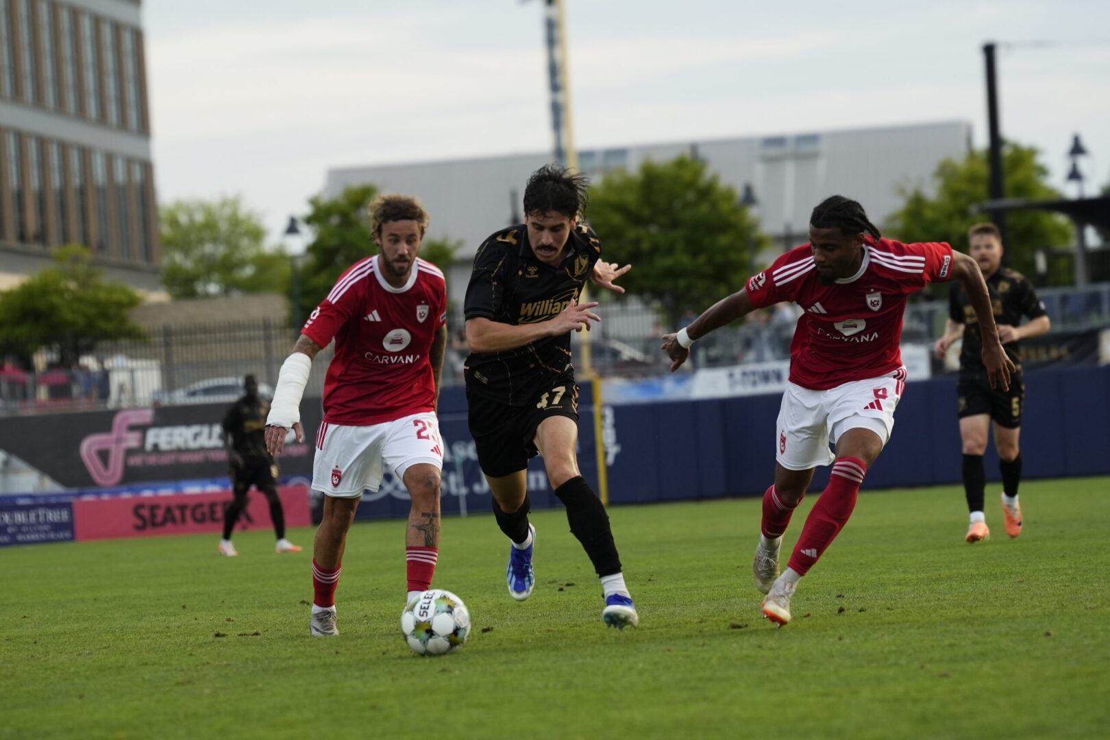 Phoenix Rising's Ihsan Sacko and Ryan Flood try to take the ball from an FC Tulsa player on June 14, 2025. Credit: Phoenix Rising FC