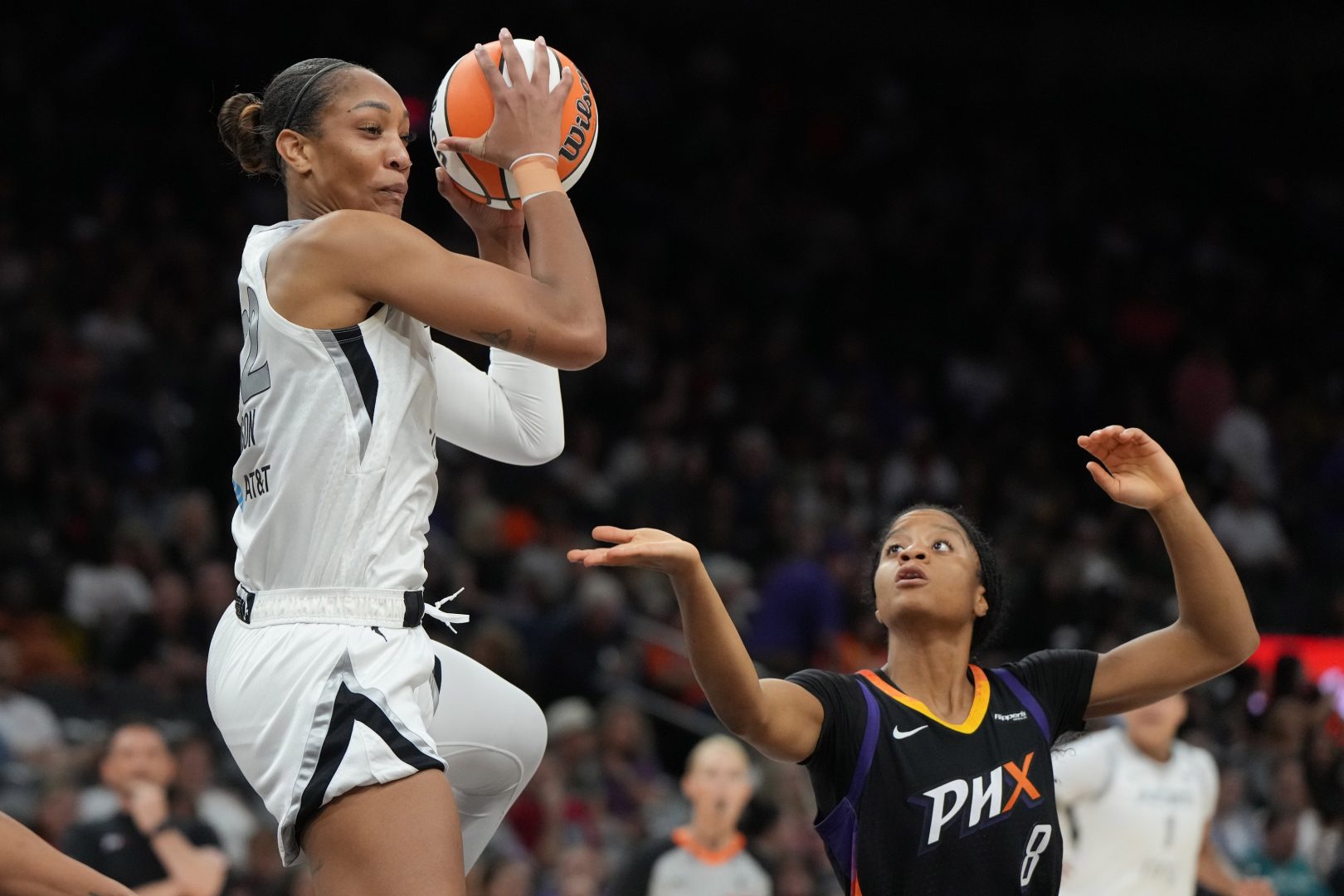 Aug 15, 2025; Phoenix, Arizona, USA; Las Vegas Aces center A'ja Wilson (22) grabs the rebound over Phoenix Mercury guard Monique Akoa Makani (8) in the second half at Footprint Center. Mandatory Credit: Rick Scuteri-Imagn Images