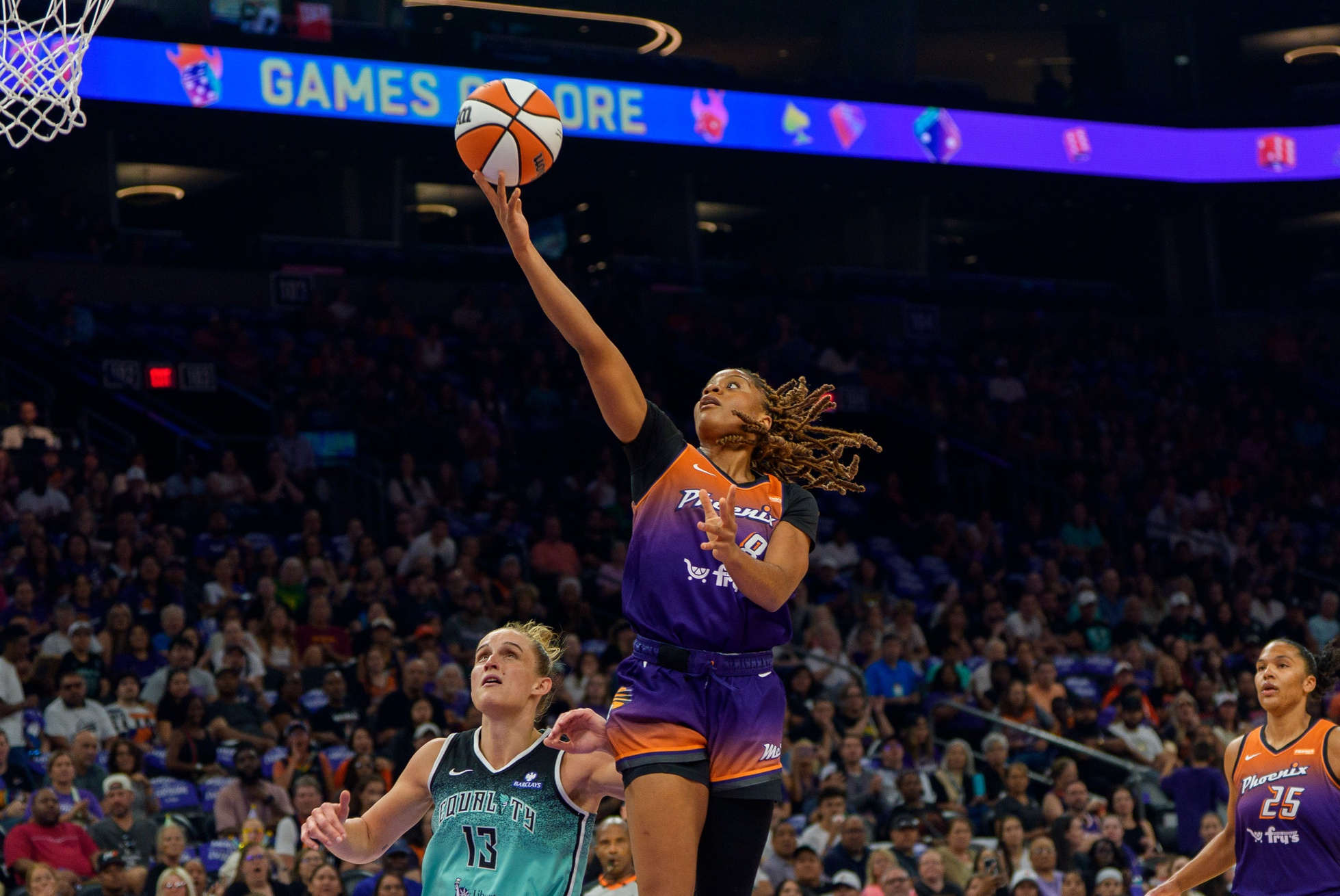 Sep 14, 2025; Phoenix, Arizona, USA; Phoenix Mercury guard Monique Akoa Makani (8) breaks away for an easy layup past New York Liberty forward Leonie Fiebich (13) in the first half during game one of the 2025 WNBA Playoffs round one at PHX Arena. Mandatory Credit: Allan Henry-Imagn Images