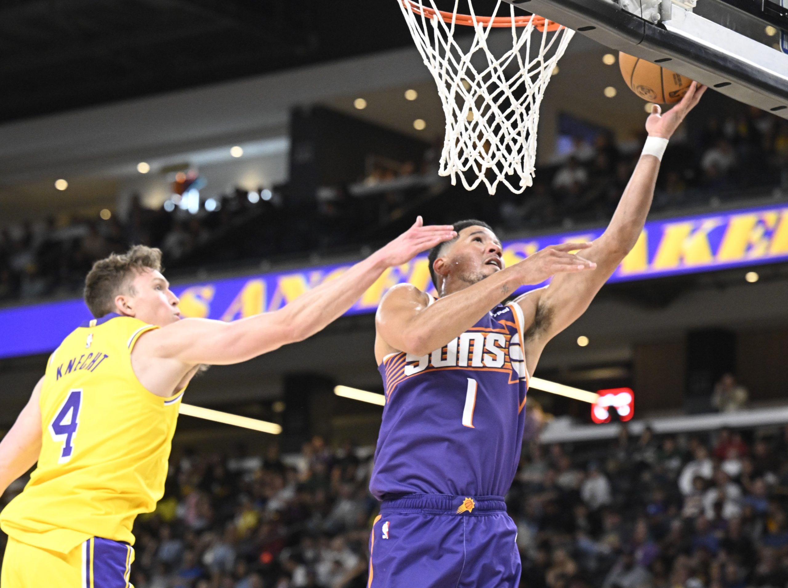 Oct 3, 2025; Palm Desert, California, USA; Phoenix Suns guard Devin Booker (1) shoots past Los Angeles Lakers guard Dalton Knecht (4) at Acrisure Arena. Mandatory Credit: Denis Poroy-Imagn Images