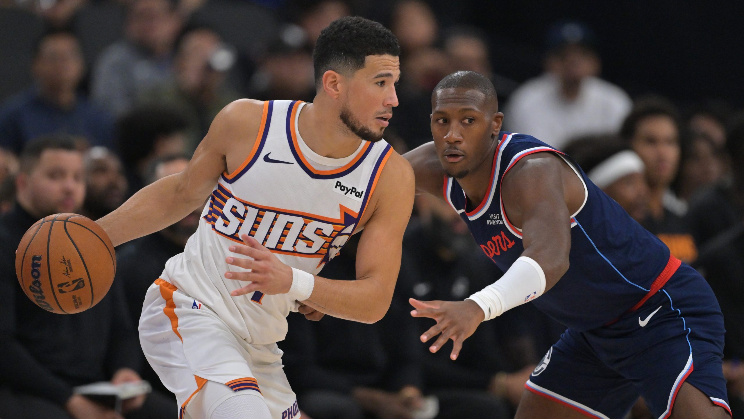 Oct 24, 2025; Inglewood, California, USA; Phoenix Suns guard Devin Booker (1) is defended by Los Angeles Clippers guard Kris Dunn (8) in the first half at Intuit Dome. Mandatory Credit: Jayne Kamin-Oncea-Imagn Images