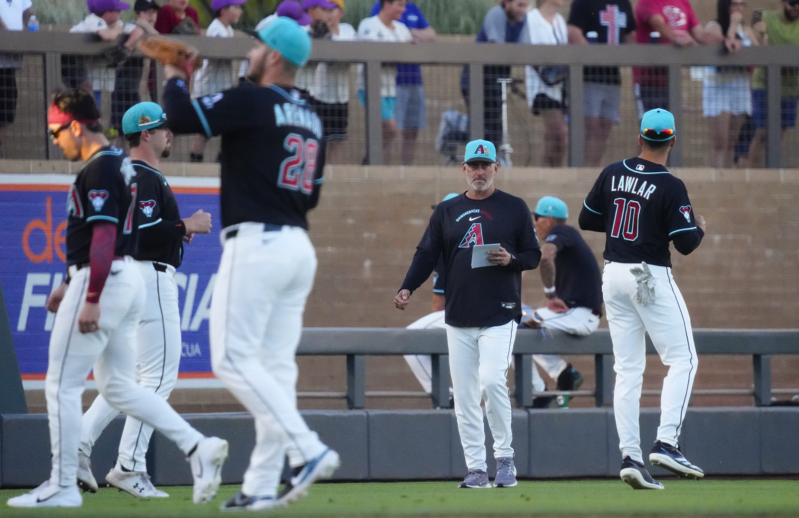 Diamondbacks manager Torey Lovullo watches his team warm-up during a spring training game against the Brewers at Salt River Fields on March 20, 2026. © Patrick Breen/The Republic / USA TODAY NETWORK via Imagn Images
