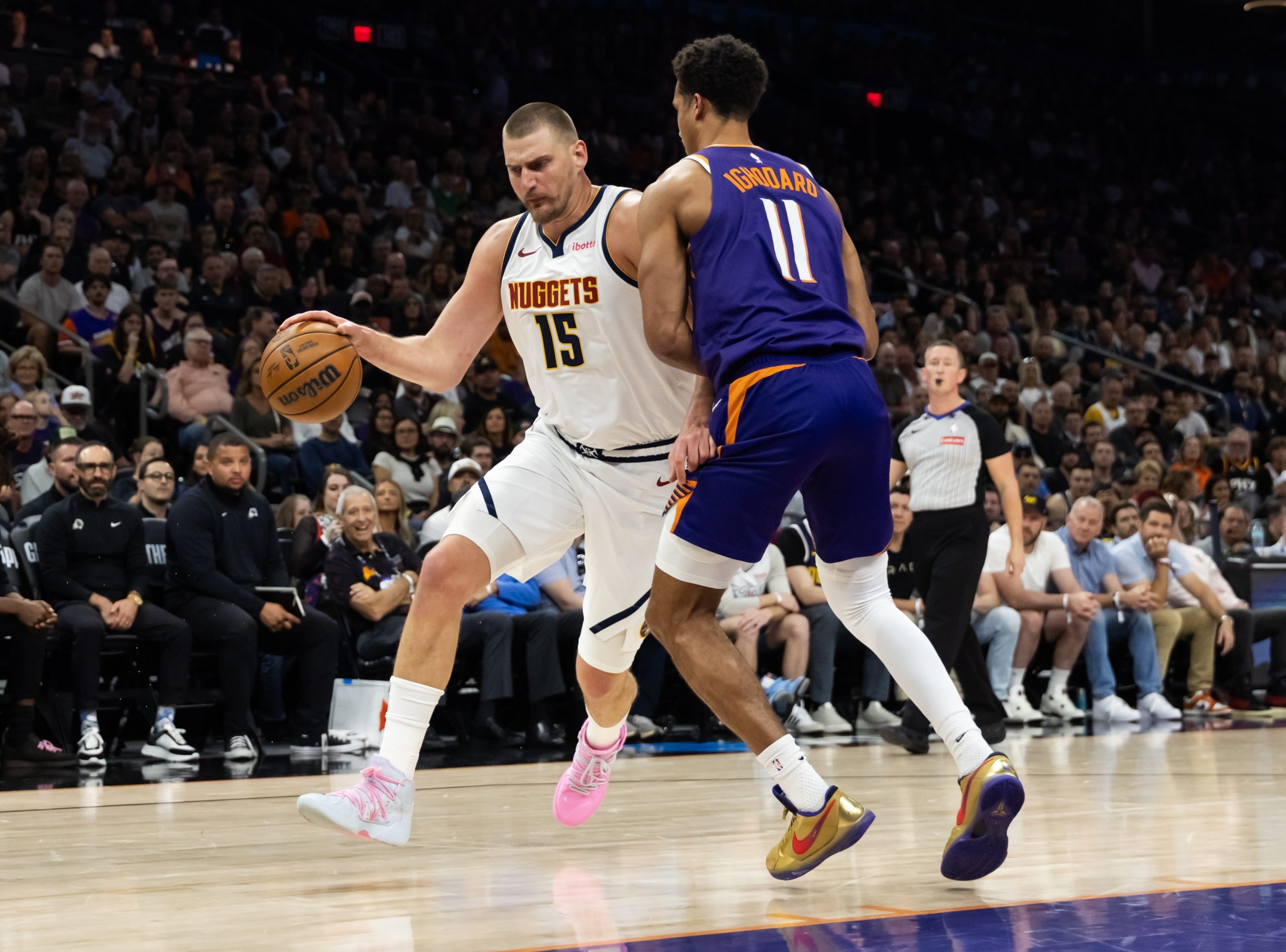 Mar 24, 2026; Phoenix, Arizona, USA; Denver Nuggets center Nikola Jokic (15) against Phoenix Suns forward Oso Ighodaro (11) in the first half at Mortgage Matchup Center. Mandatory Credit: Mark J. Rebilas-Imagn Images
