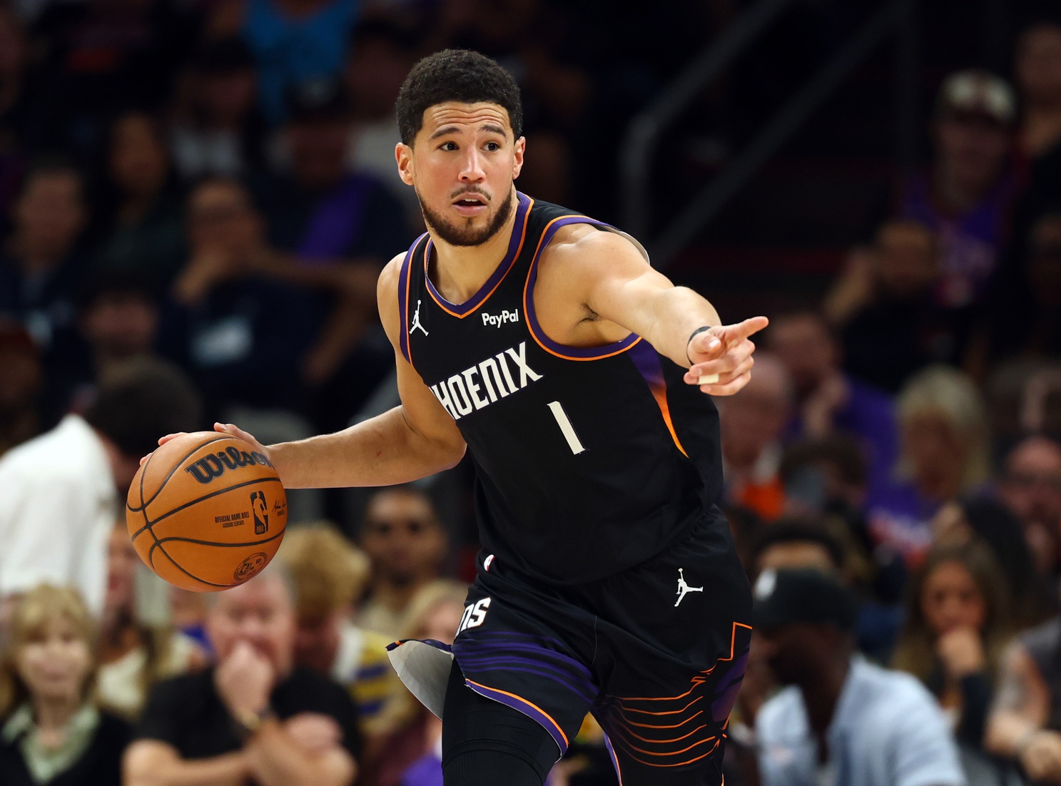 Apr 17, 2026; Phoenix, Arizona, USA; Phoenix Suns guard Devin Booker (1) against the Golden State Warriors during the first half in the play-in rounds of the 2026 NBA Playoffs at Mortgage Matchup Center. Mandatory Credit: Mark J. Rebilas-Imagn Images