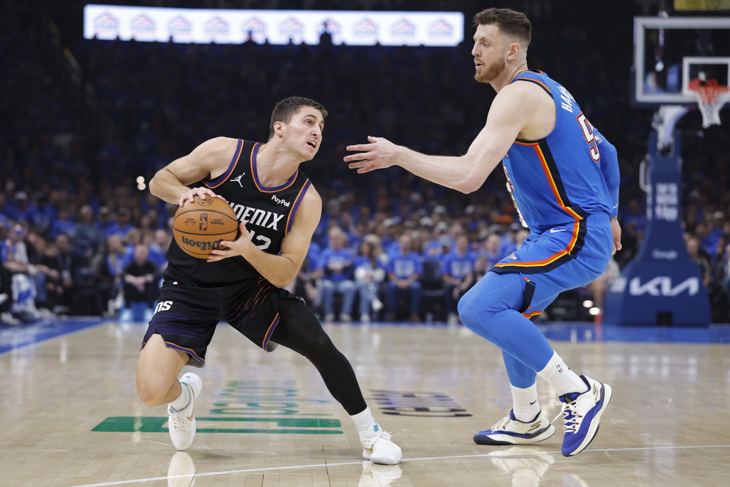 Apr 19, 2026; Oklahoma City, Oklahoma, USA; Phoenix Suns guard Collin Gillespie (12) moves the ball around Oklahoma City Thunder center Isaiah Hartenstein (55) in the second quarter during game one of the first round of the 2026 NBA Playoffs at Paycom Center. Mandatory Credit: Alonzo Adams-Imagn Images