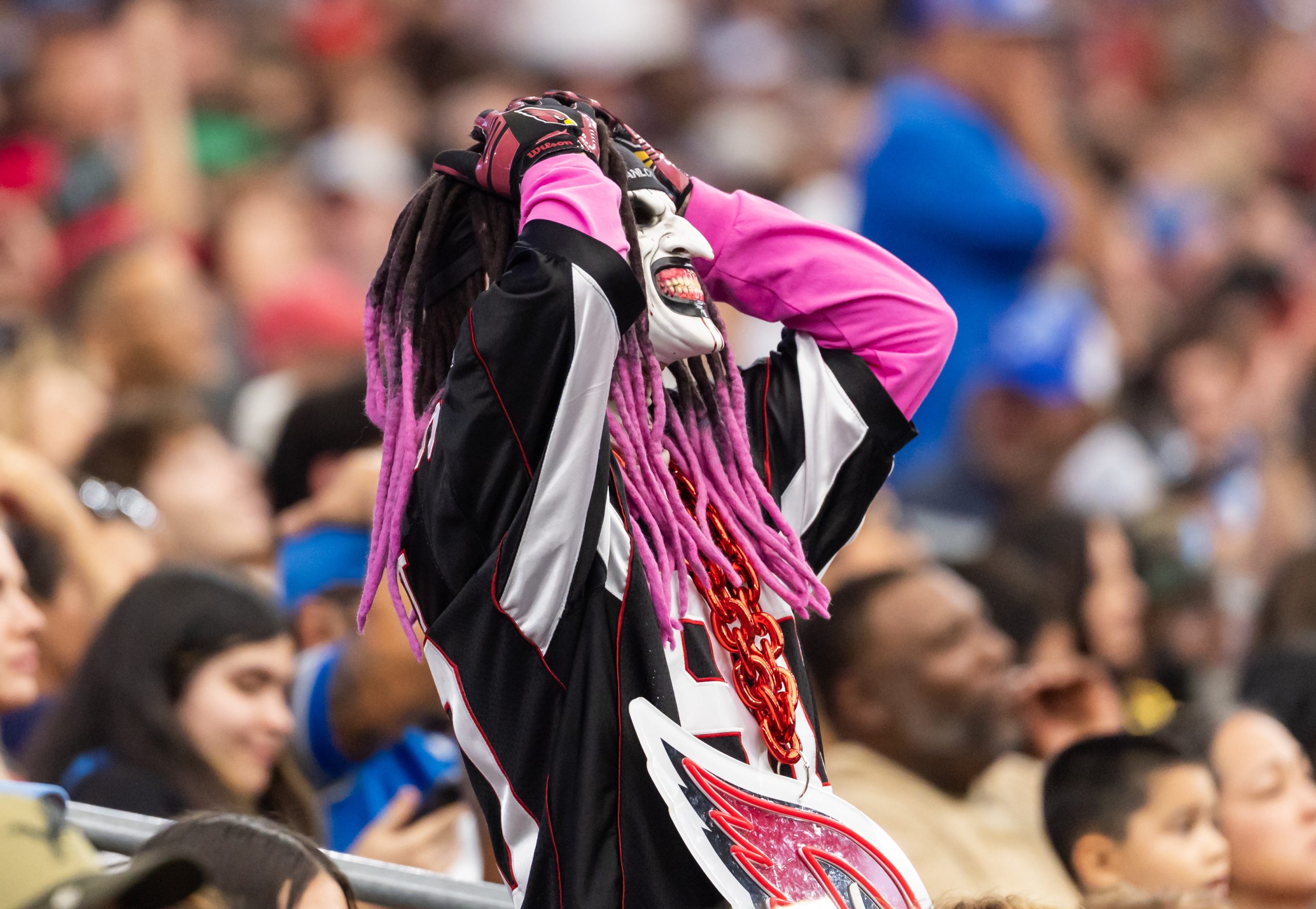 Oct 11, 2026; Glendale, Arizona, USA; An Arizona Cardinals fan reacts as he wears a mask in the crowd against the Detroit Lions at State Farm Stadium. Mandatory Credit: Mark J. Rebilas-Imagn Images